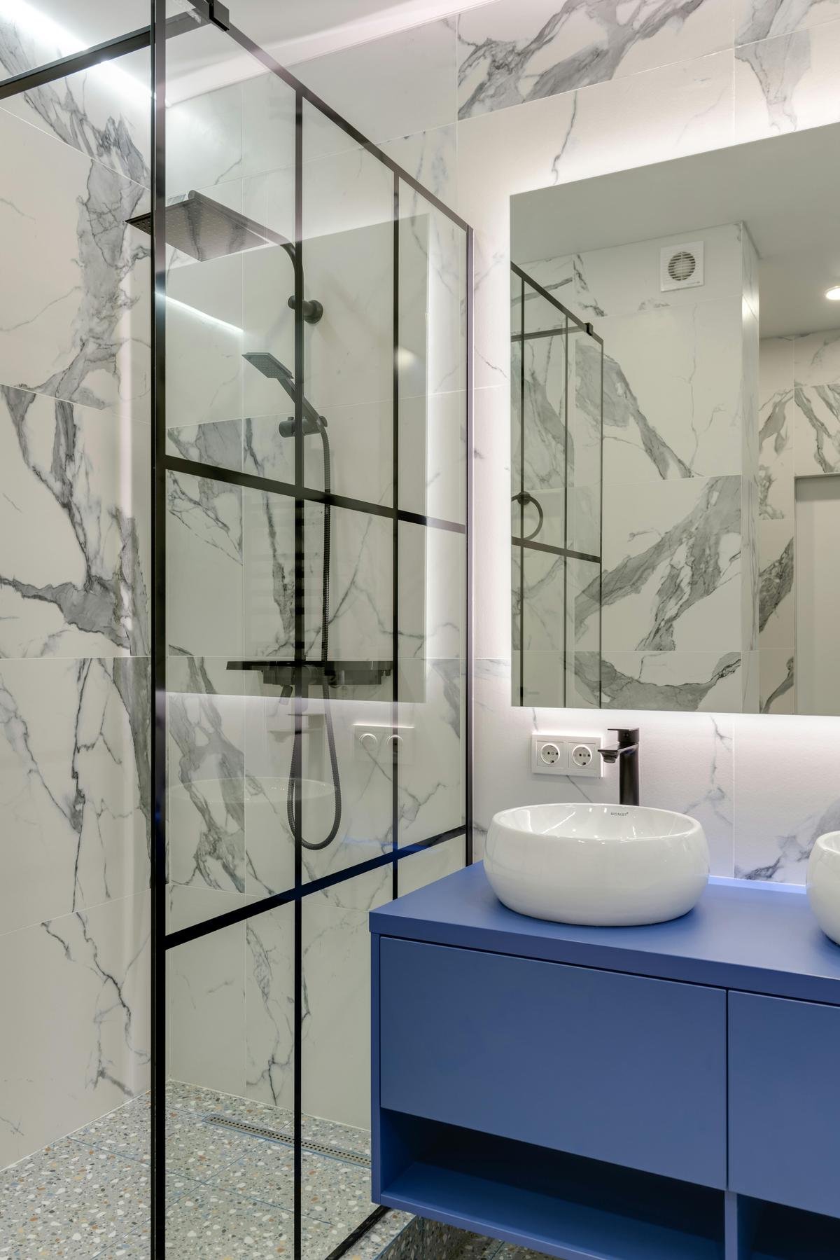 Custom blue vanity with vessel sink and backlit mirror